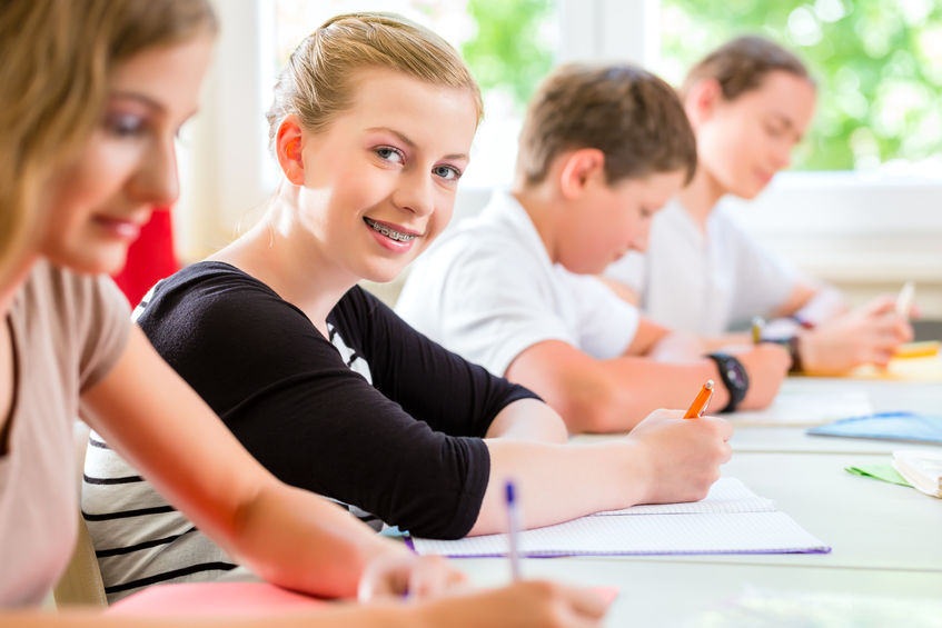 22401319-Students-or-pupils-of-school-class-writing-an-exam-test-in-classroom-concentrating-on-their-work-Stock-Photo